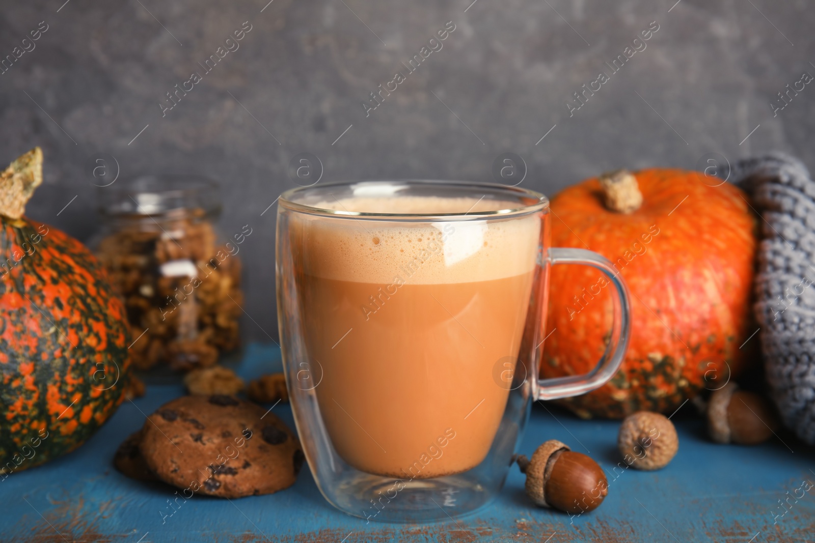 Photo of Composition with tasty pumpkin spice latte in glass cup on table