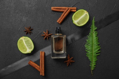 Photo of Beautiful composition with bottle of perfume on dark background, flat lay