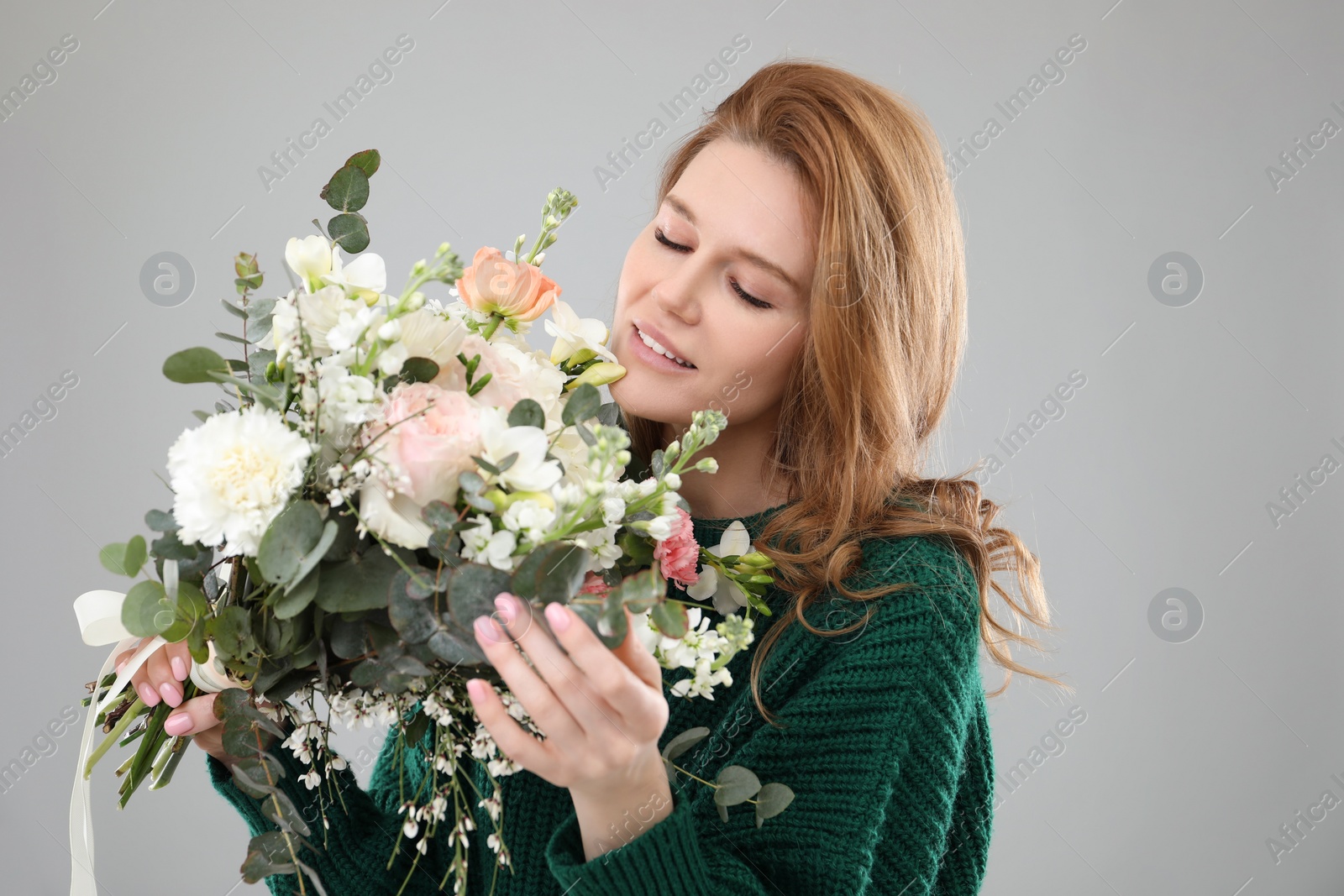 Photo of Beautiful woman with bouquet of flowers on grey background