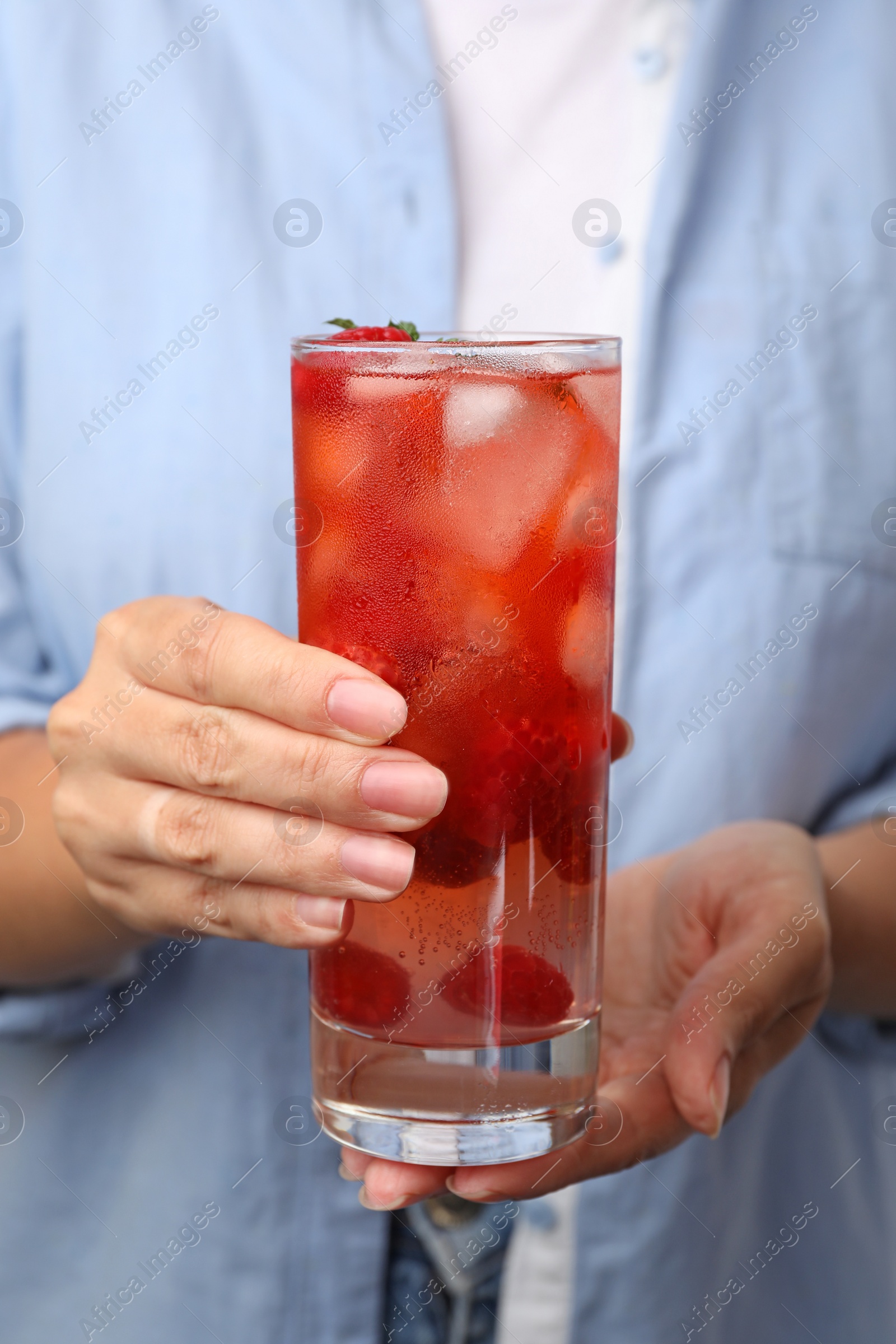 Photo of Woman holding glass of raspberry refreshing drink, closeup