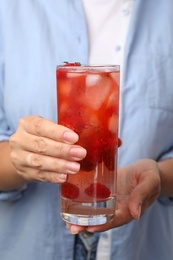 Photo of Woman holding glass of raspberry refreshing drink, closeup