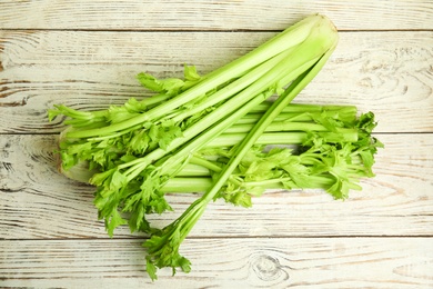 Fresh ripe green celery on white wooden table, flat lay