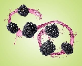 Image of Fresh blackberries and juice in air on light green background