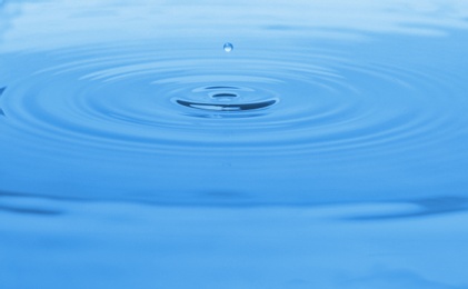 Photo of Splash of blue water with drop, closeup