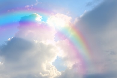 Image of Beautiful view of bright rainbow in blue sky on sunny day