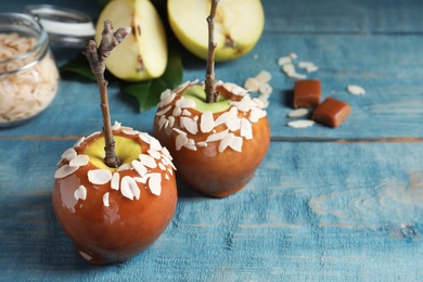 Photo of Delicious caramel apples on wooden background