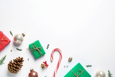 Flat lay composition with Christmas gifts and festive decor on white background. Space for text