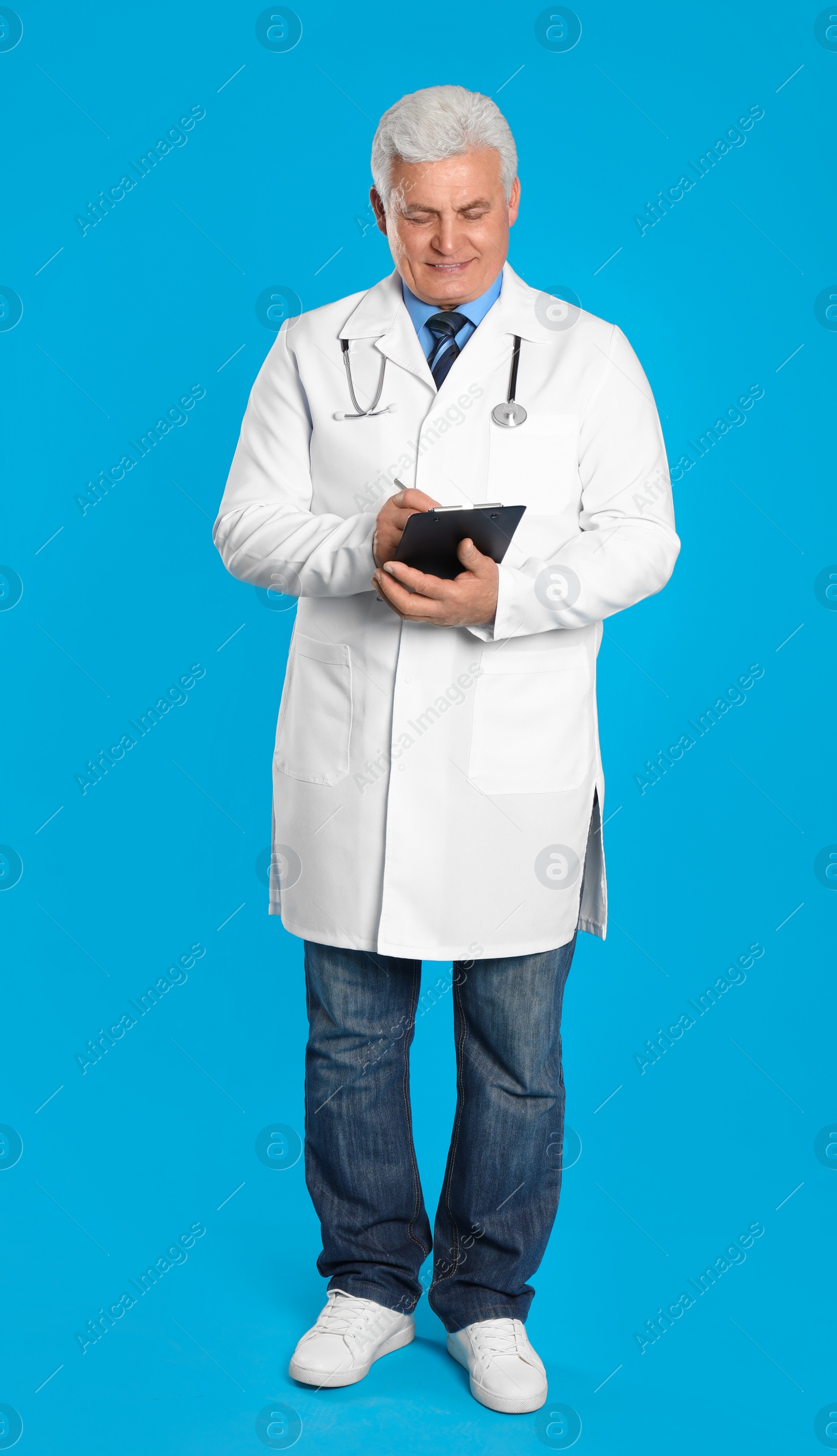 Photo of Senior doctor with clipboard on light blue background