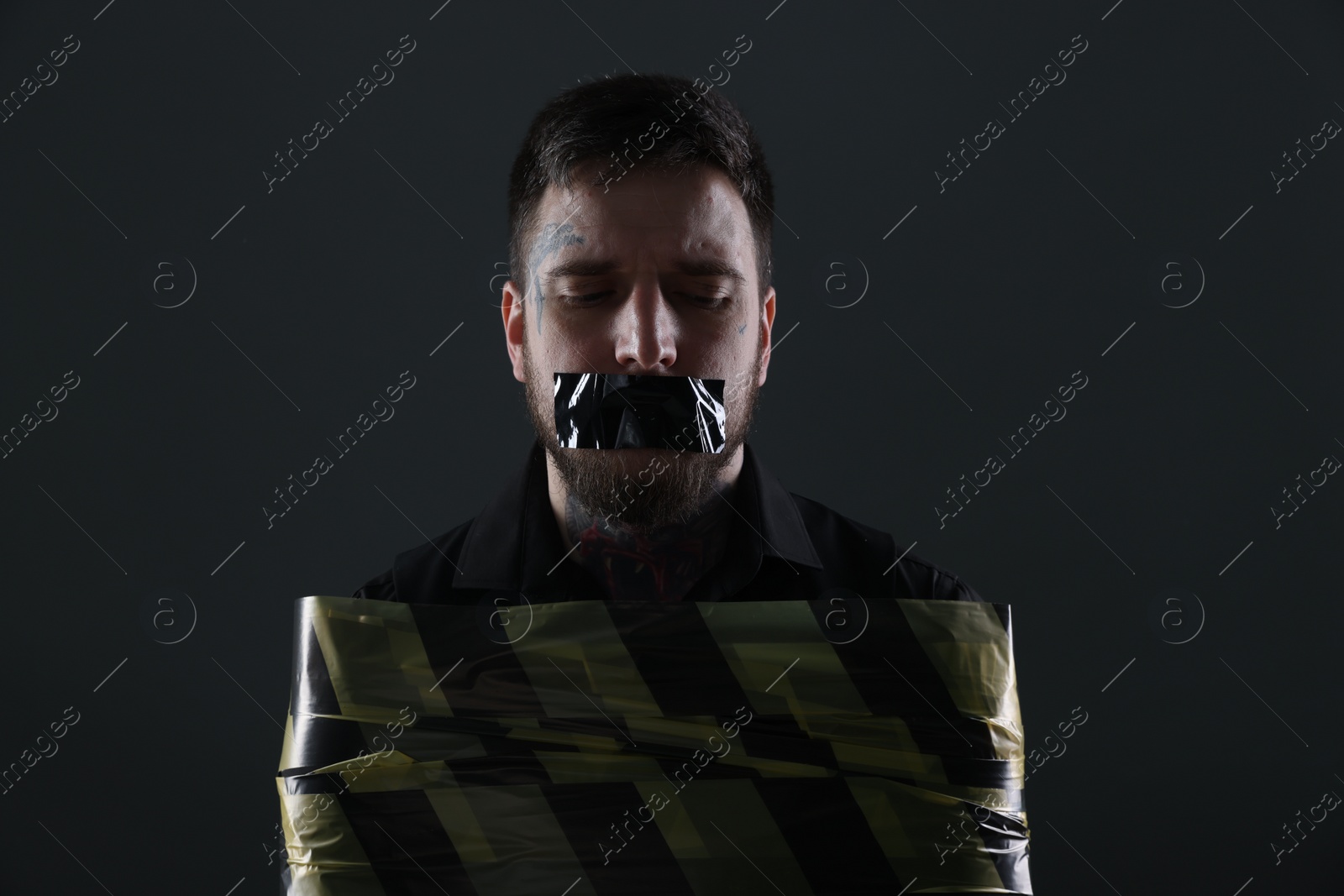 Photo of Man taped up and taken hostage on dark background