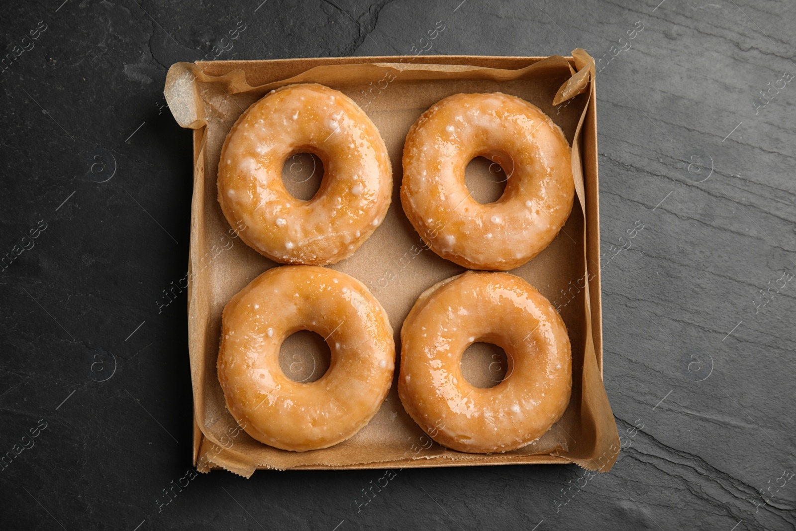 Photo of Delicious donuts on black table, top view