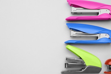 New bright staplers on white background, flat lay. Space for text