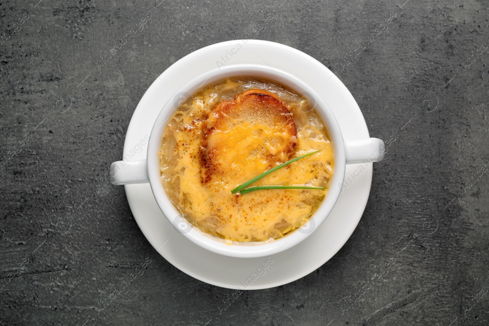 Photo of Tasty homemade french onion soup on grey table, top view