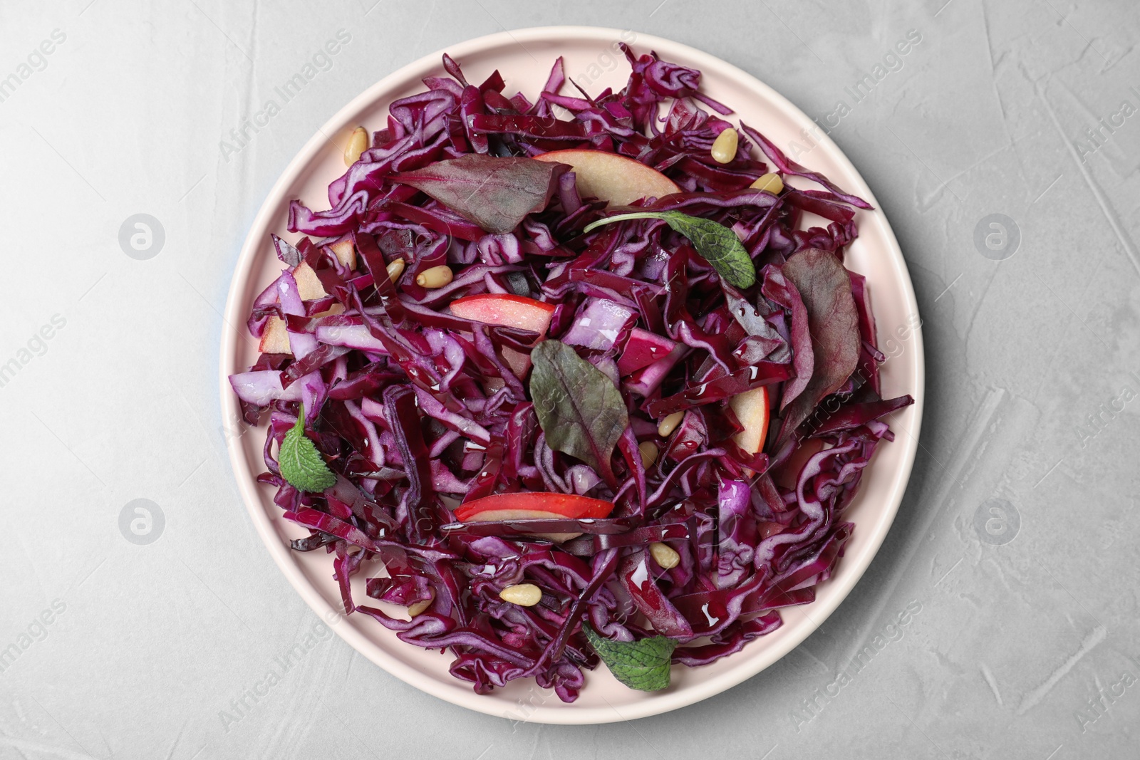 Photo of Fresh red cabbage salad served on light grey table, top view