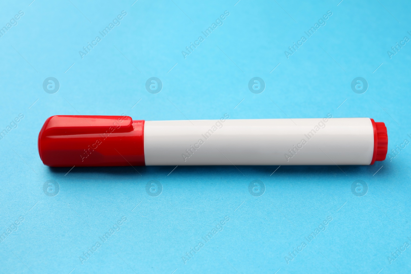 Photo of Bright red marker on light blue background