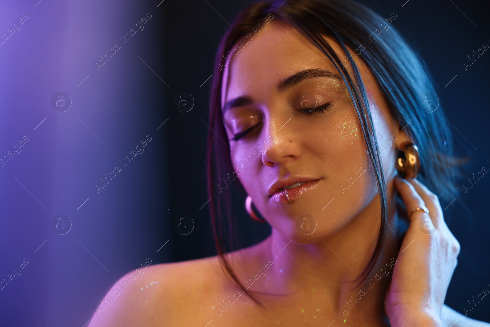 Photo of Portrait of beautiful woman on dark background in neon lights