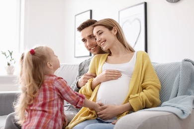 Young pregnant woman with her family at home