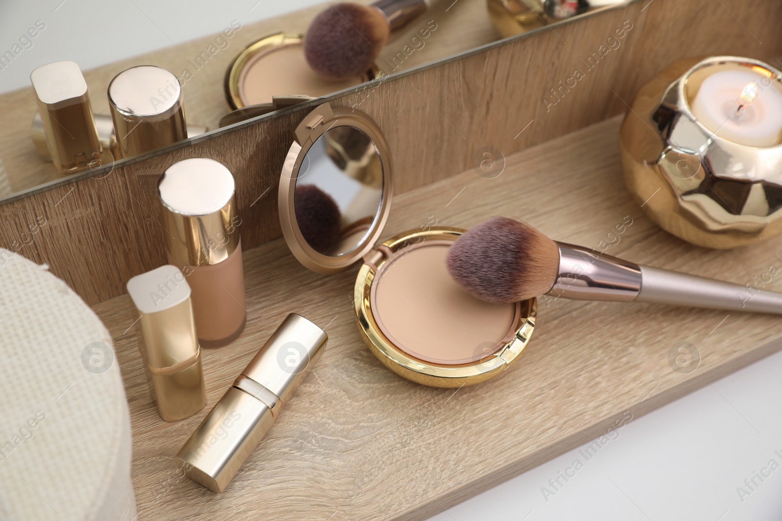 Photo of Different decorative cosmetic products on wooden table, above view