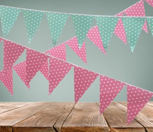 Image of Empty wooden table and decorative bunting flags 