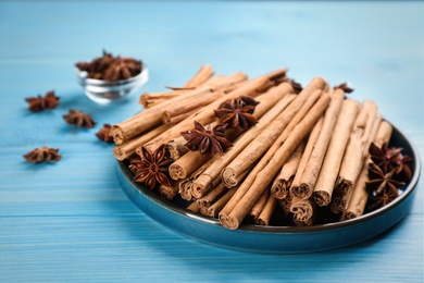 Aromatic cinnamon sticks and anise on light blue wooden table