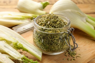 Photo of Fennel seeds in jar and fresh vegetables on table, closeup