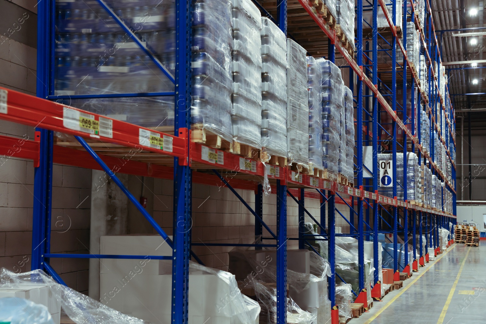 Photo of Warehouse interior with metal racks full of merchandise. Wholesale business