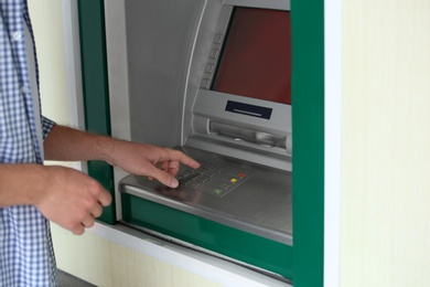 Man using cash machine for money withdrawal outdoors, closeup