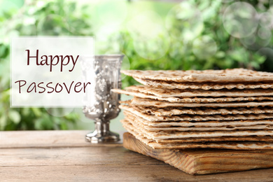 Image of Traditional Matzos and silver goblet on wooden table. Pesach (Passover) celebration