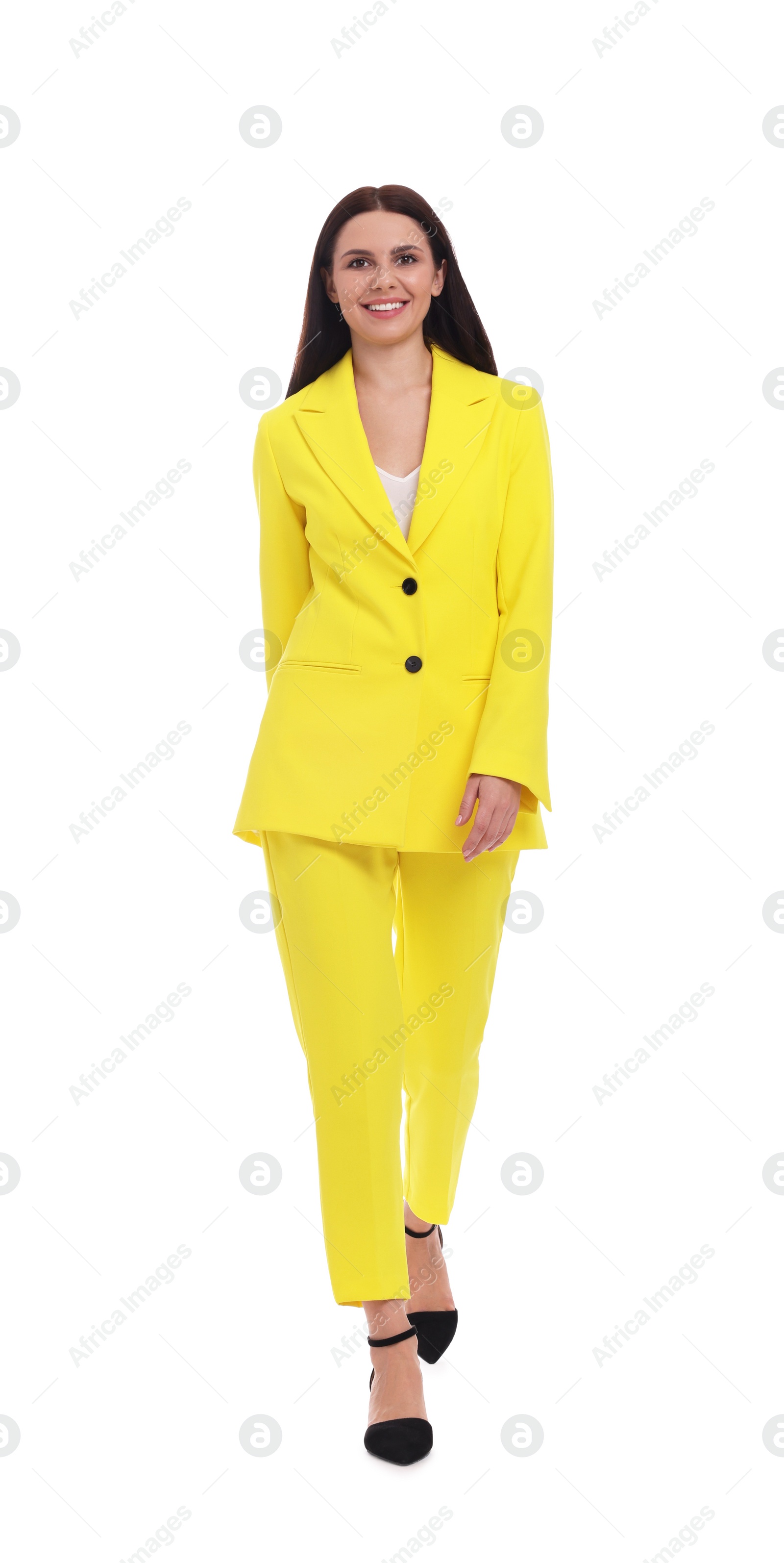 Photo of Beautiful businesswoman in yellow suit walking on white background