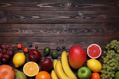 Photo of Different ripe fruits on wooden table, top view. Space for text