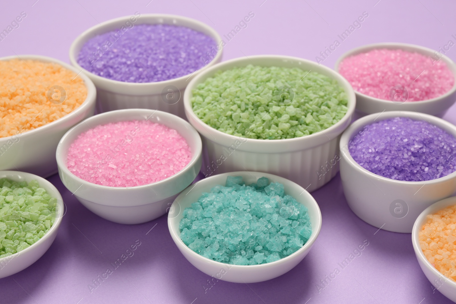 Photo of Different types of aromatic sea salt on purple background