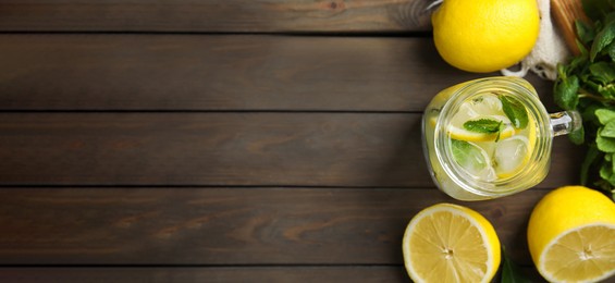 Mason jar of cold lemonade and ingredients on wooden table, flat lay with space for text. Banner design