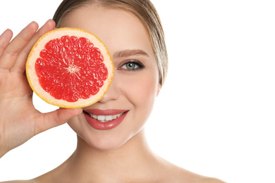 Young woman with cut grapefruit on white background. Vitamin rich food