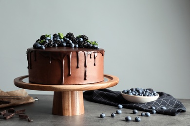 Photo of Fresh delicious homemade chocolate cake with berries on table against gray background. Space for text