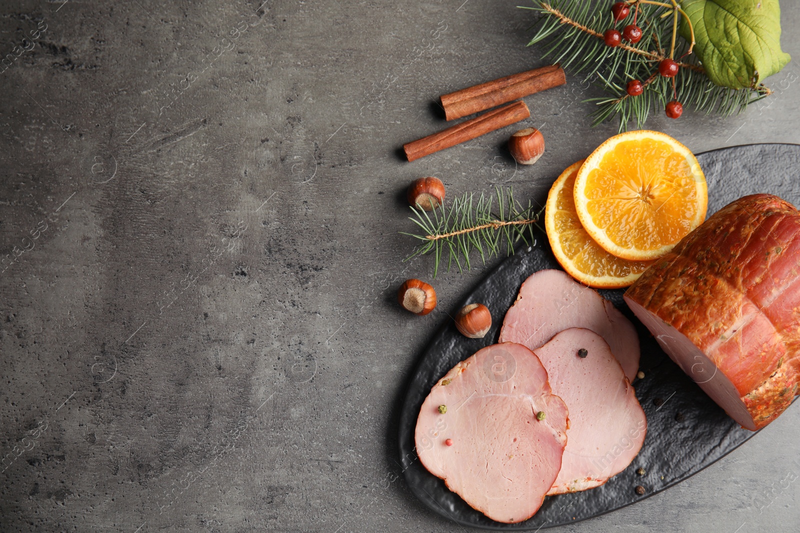 Photo of Flat lay composition with delicious ham on grey table, space for text. Christmas dinner