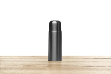 Photo of Stylish thermo bottle on wooden table against white background