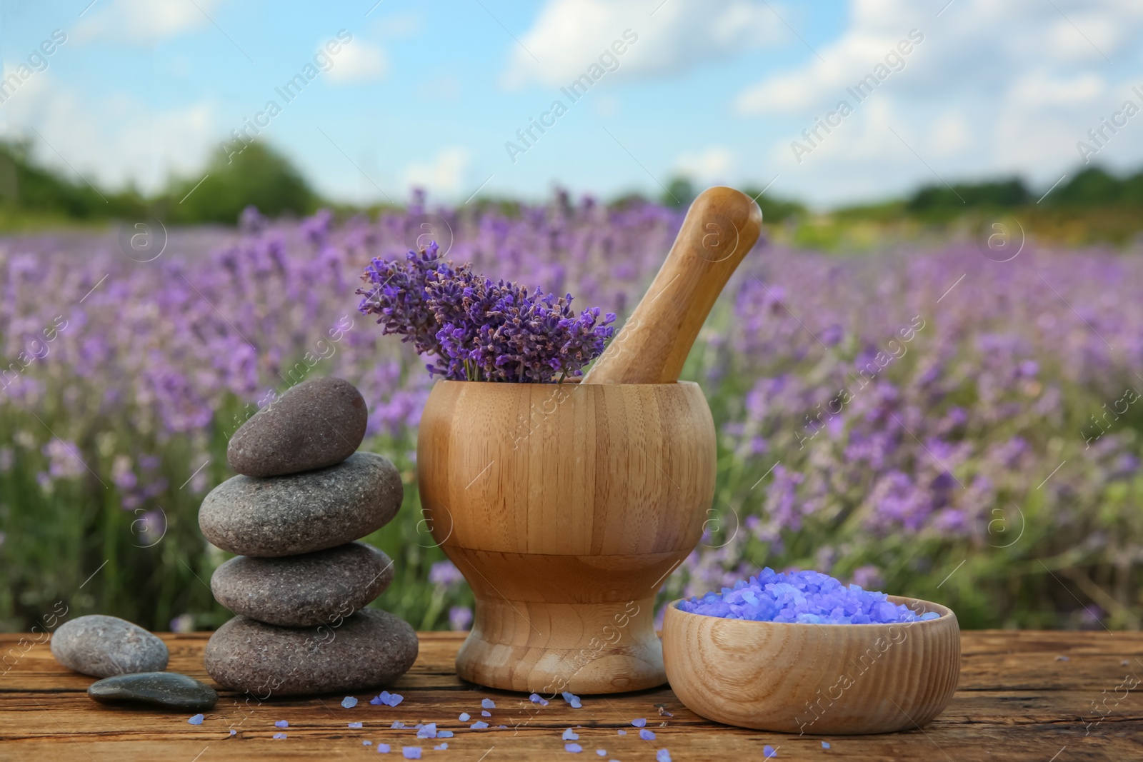 Photo of Spa composition with fresh lavender flowers on wooden table outdoors