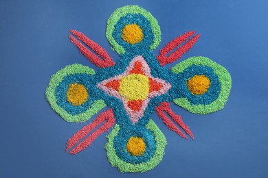 Photo of Diwali celebration. Composition with colorful rangoli on blue background, top view