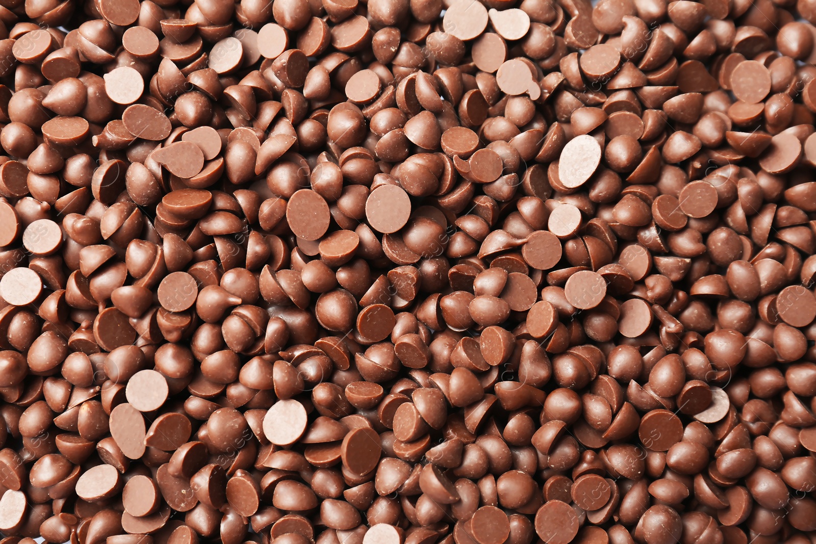 Photo of Many delicious milk chocolate chips as background