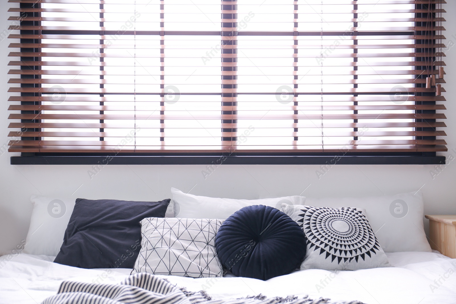 Photo of Modern room interior with comfortable double bed and window blinds