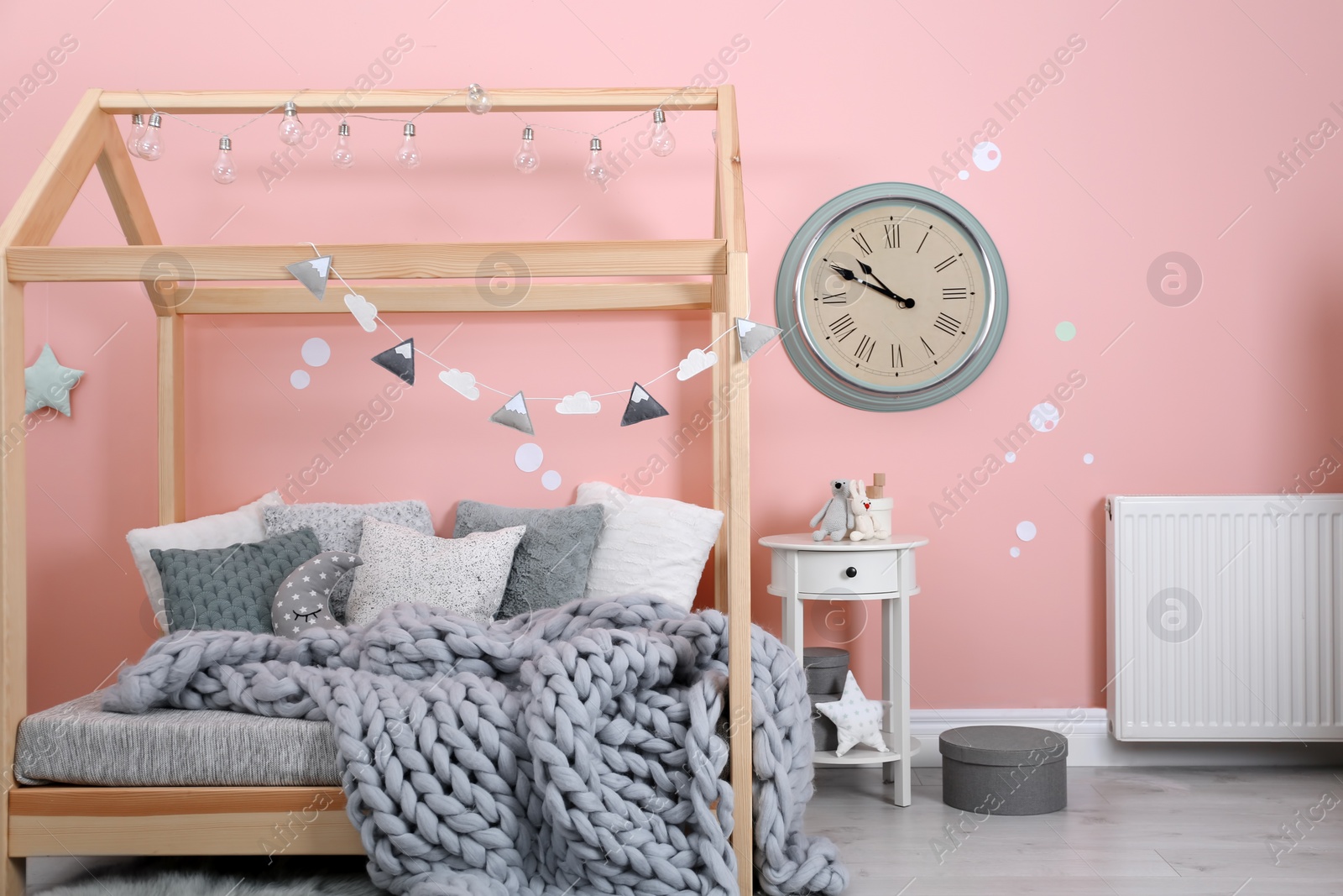 Photo of Child's room interior with comfortable bed and garland