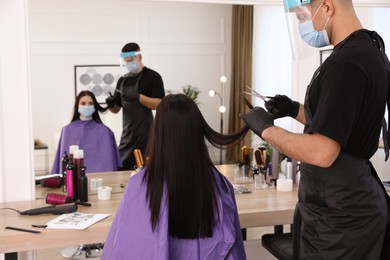 Professional stylist working with client in salon. Hairdressing services during Coronavirus quarantine