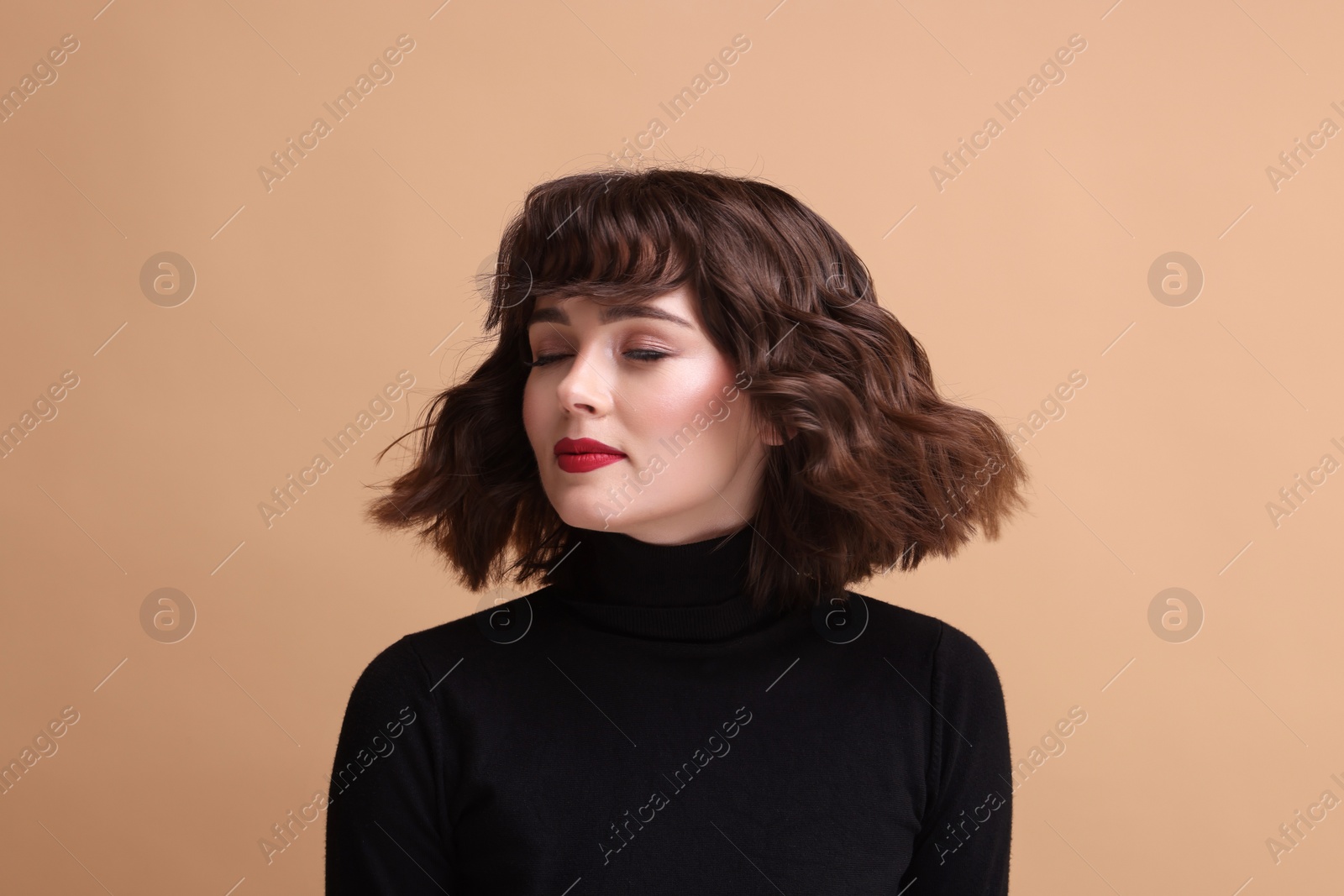 Photo of Portrait of beautiful young woman with wavy hairstyle on beige background