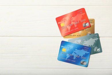 Photo of Different credit cards on white wooden table, flat lay. Space for text
