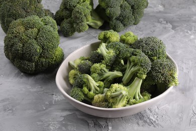 Photo of Bowl of fresh raw broccoli on grey textured table