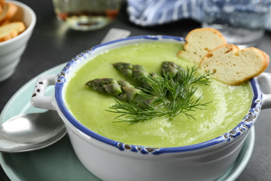 Delicious asparagus soup served in bowl, closeup