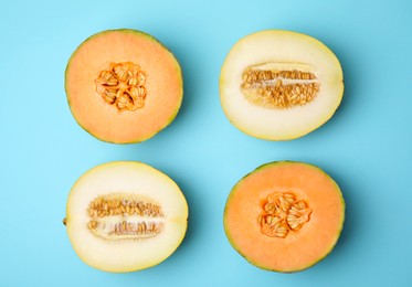 Tasty colorful ripe melons on light blue background, flat lay