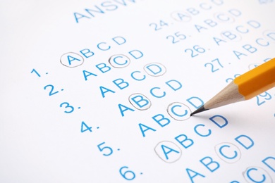 Filling answer sheet with pencil, closeup view