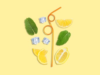 Image of Creative lemonade layout with lemon slices, mint, ice cubes and straws on beige background, top view