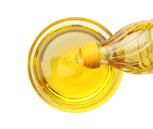 Pouring cooking oil from bottle into bowl isolated on white, top view