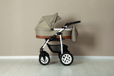 Baby carriage. Modern pram near beige wall